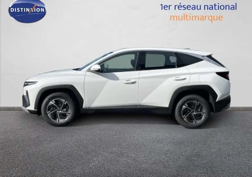 Hyundai Tucson blanc atlas en profil droit, SUV hybride 2026 avec jantes alliage et lignes anguleuses marquées.