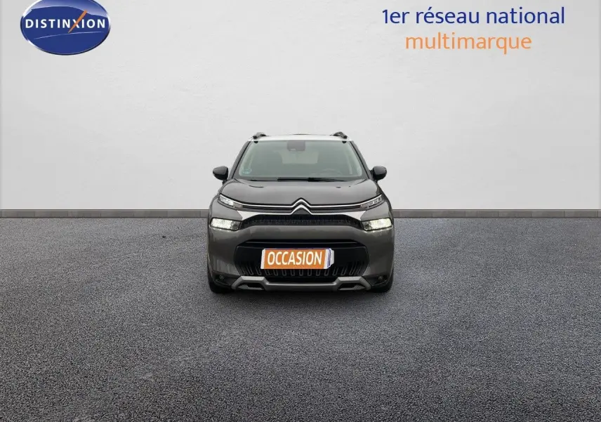 Vue frontale d'un Citroën C3 Aircross gris platinium métal avec plaque "OCCASION" sur un sol gris.