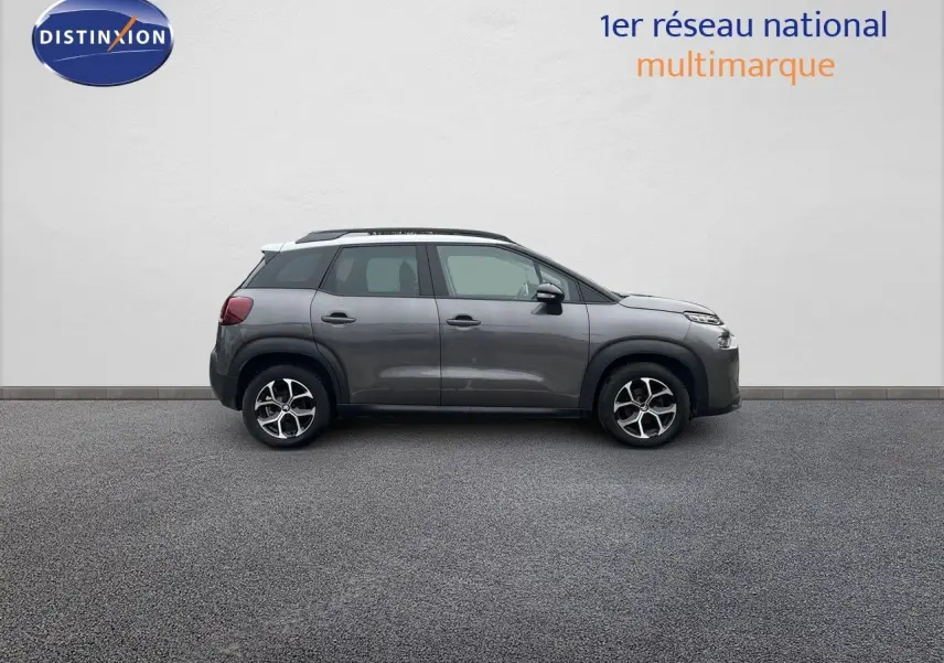 Profil droit d'un Citroën C3 Aircross 2023 gris platinium métallisé avec jantes alliage bi-ton sur fond neutre.