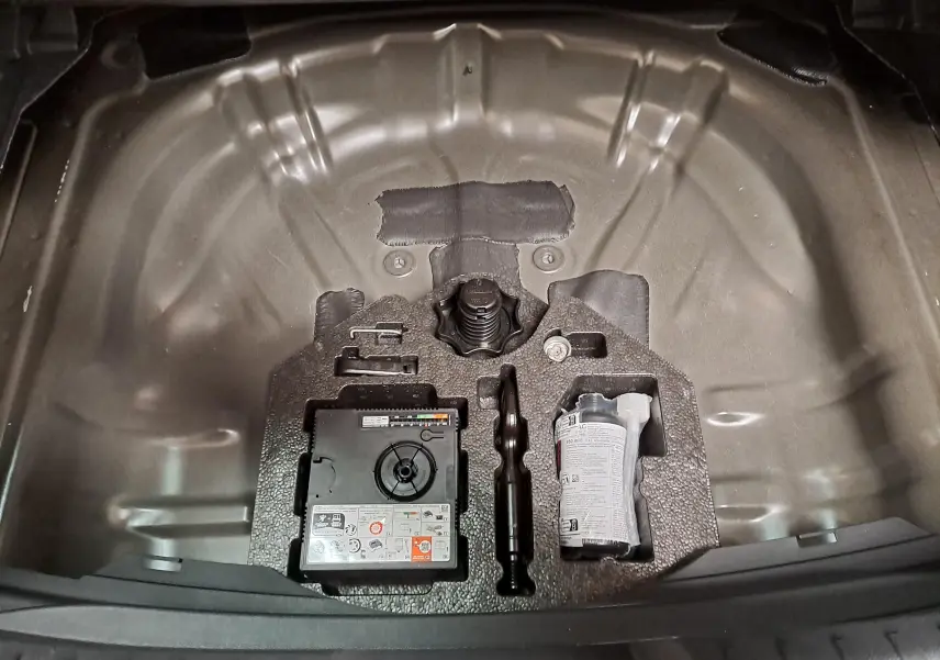 Rangement sous le coffre de la CUPRA Leon Ph.2 noir minuit, montrant kit de réparation pneus et outils intégrés.