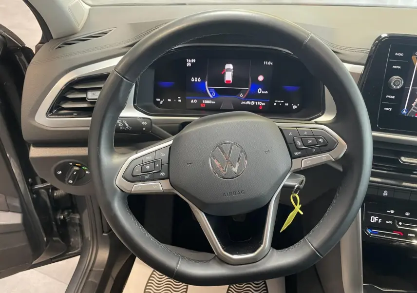 Vue intérieure centrée sur le volant cuir multifonction et le tableau de bord digital du Volkswagen T-Roc gris Indium.