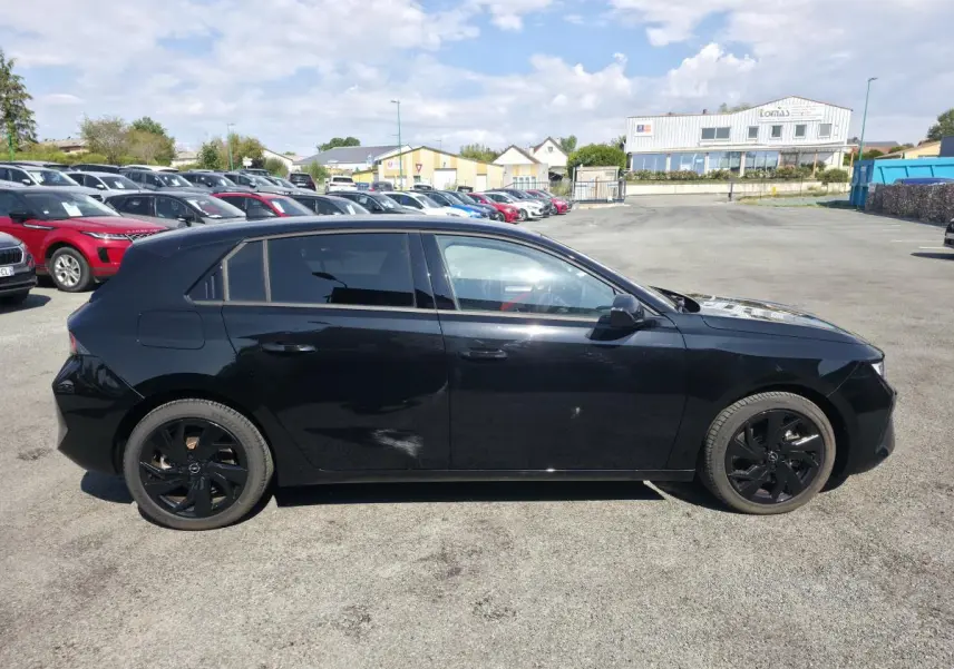 Opel Astra Hybrid 2024 noir vue de profil côté gauche avec jantes alliage noires et vitres surteintées.