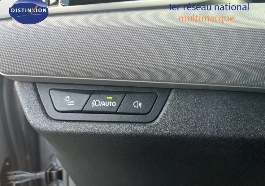 Gros plan sur les commandes d’éclairage avec bouton auto allumé, tableau de bord gris et noir d’une BMW Série 2 Active Tourer 2022.