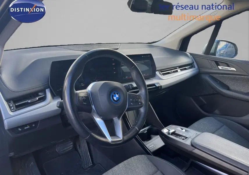 Vue intérieure côté conducteur de la BMW Série 2 Active Tourer 225e XDrive 2022 avec tableau de bord moderne et sièges gris.