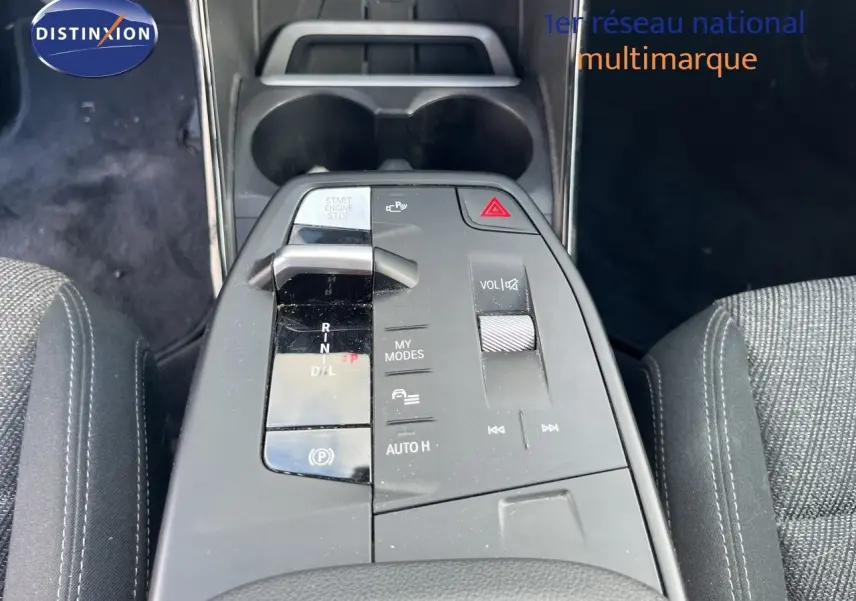 Vue plongeante sur la console centrale de la BMW Série 2 Active Tourer grise, montrant la commande de boîte automatique et les boutons de contrôle.