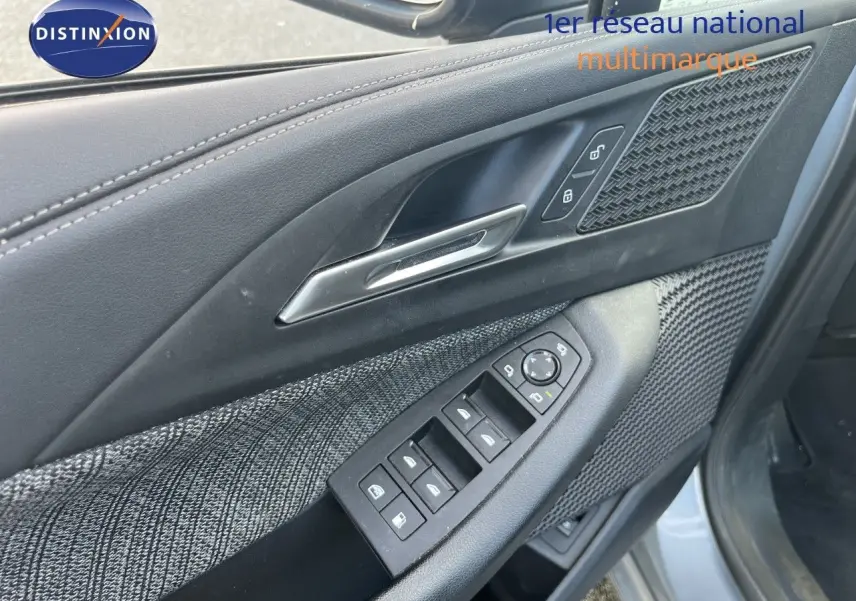 Gros plan sur la porte avant gauche de la BMW Série 2 Active Tourer 225e XDrive, avec garniture tissu et commandes électriques.