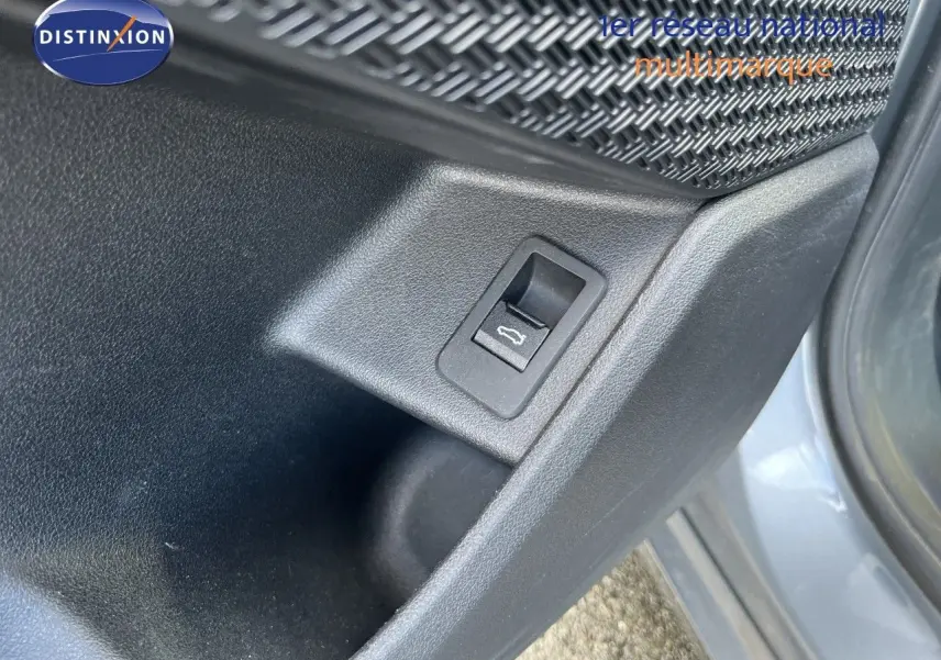 Détail du bouton d'ouverture du coffre sur la porte côté gauche d'une BMW Série 2 Active Tourer gris métallisé.
