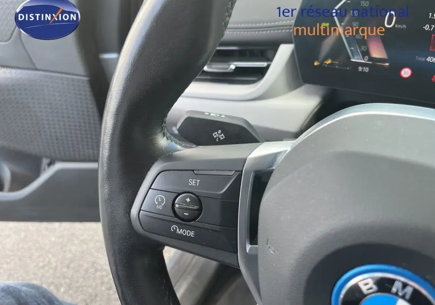 Gros plan sur le volant cuir noir de la BMW Série 2 Active Tourer 225e XDrive, avec commandes intégrées et tableau de bord numérique.
