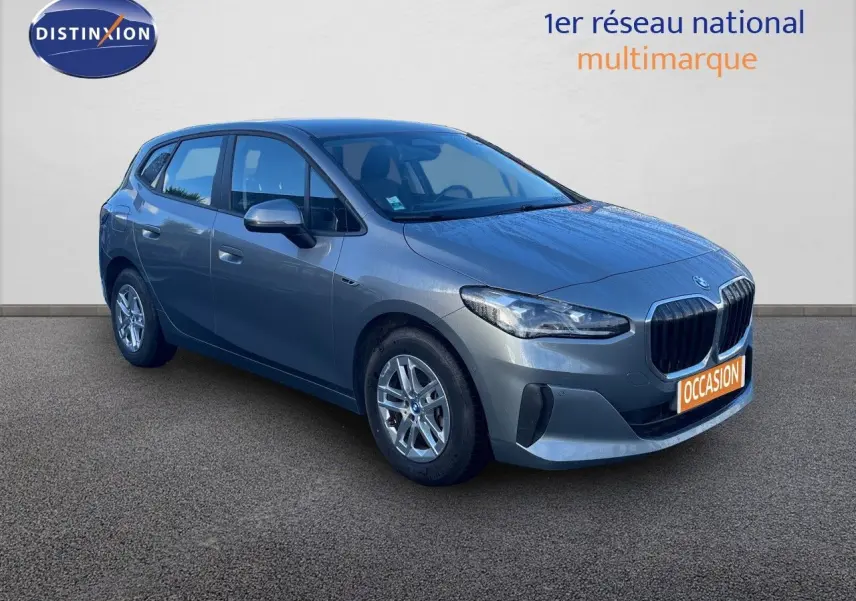 Vue 3/4 avant droite d'une BMW Série 2 Active Tourer hybride gris métallisé avec calandre imposante et jantes argentées.