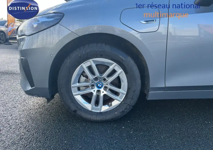 Gros plan sur la roue avant gauche d'une BMW Série 2 Active Tourer gris métallisé avec badge "electrified" sur l'aile.