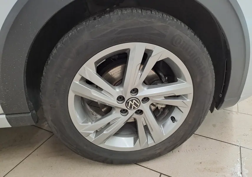 Gros plan sur la roue avant droite du Volkswagen Taigo 2024 en peinture métallisée Reflet d'argent avec jante alliage R-Line.