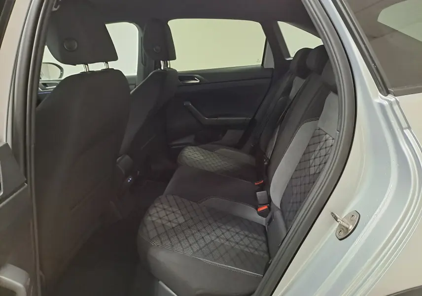 Vue intérieure côté droit montrant les sièges arrière en tissu noir avec motifs géométriques du Volkswagen Taigo 2024 Reflet d'argent.