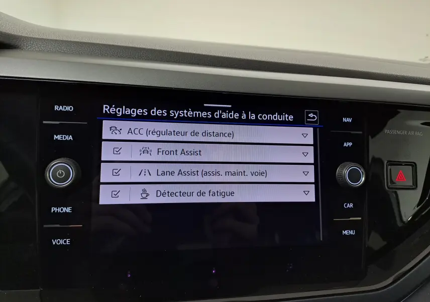 Écran central du Volkswagen Taigo 2024 affichant les réglages des aides à la conduite avec interface moderne noire.
