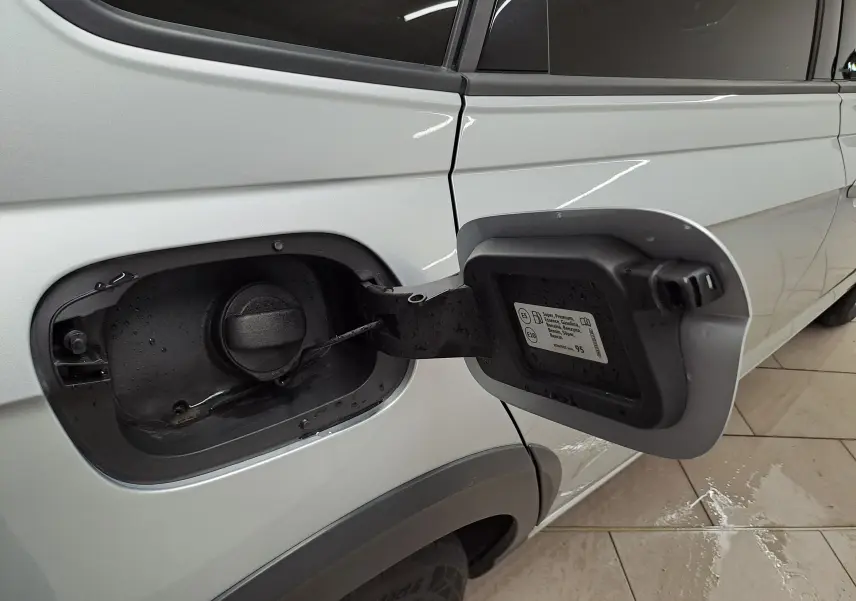 Trappe à carburant ouverte côté gauche du Volkswagen Taigo 1.0 TSI 110 DSG7 R-LINE en peinture métallisée reflet d'argent.