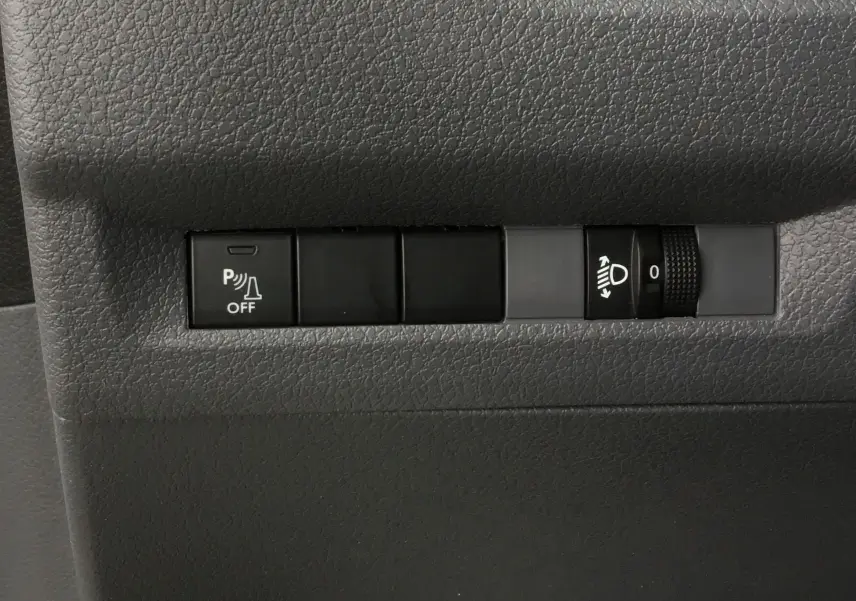 Détail des commandes de réglage des phares et désactivation du radar de recul dans un Opel Vivaro blanc 2022.