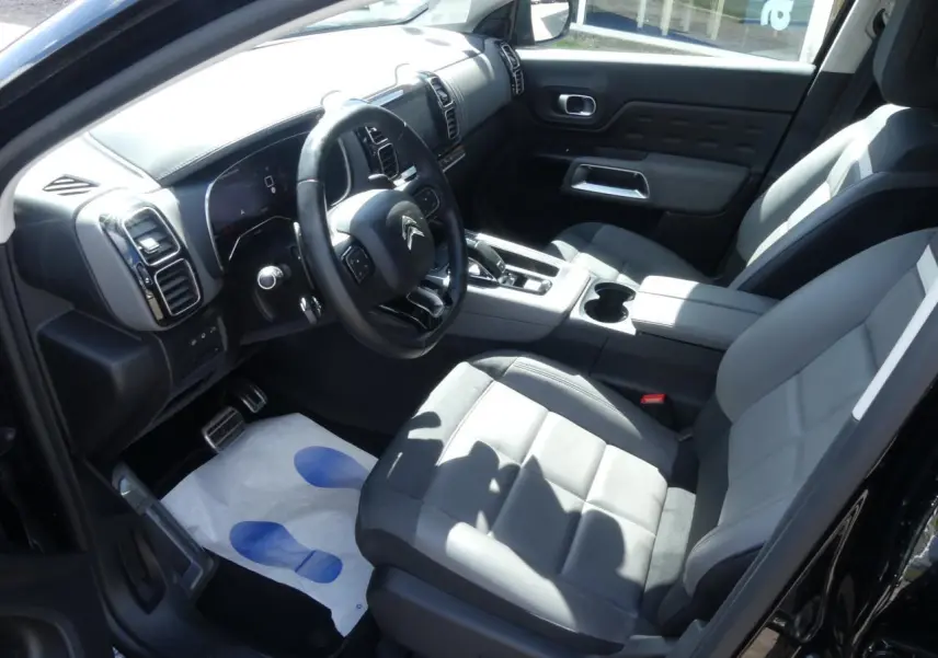 Intérieur avant droit du Citroën C5 Aircross noir, sièges cuir gris, volant multifonction et console centrale avec boîte auto.