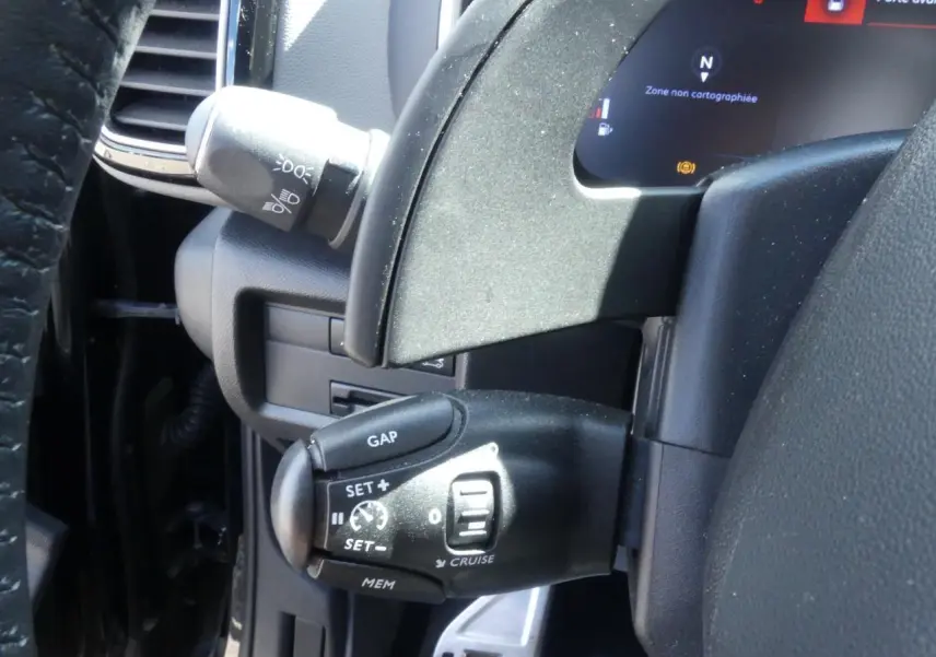 Commande de régulateur de vitesse noire sur le volant cuir du Citroën C5 Aircross 2020, vue intérieure côté gauche.