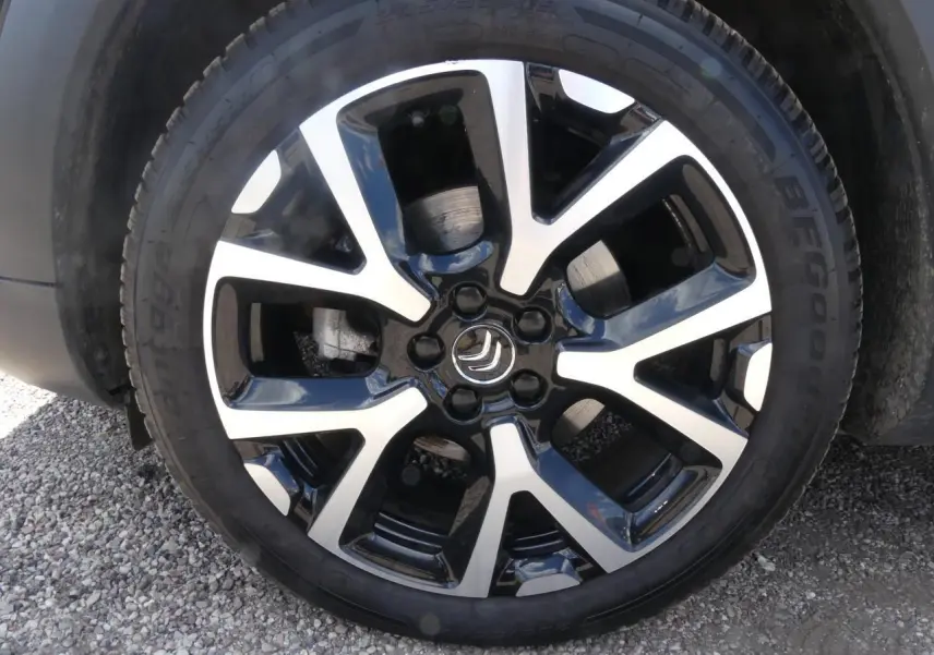 Gros plan sur la jante alliage 19 pouces diamantée noire et argentée du Citroën C5 Aircross noir, côté gauche.