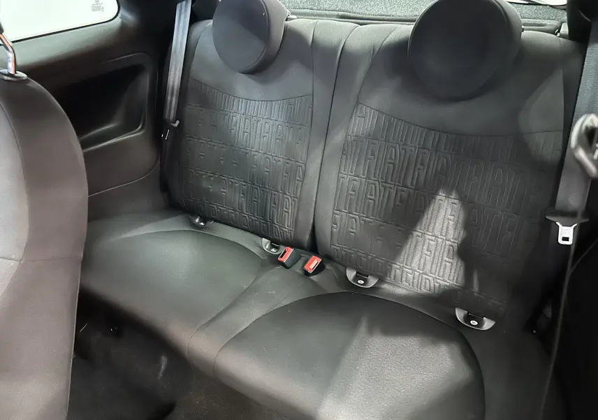 Vue intérieure arrière des sièges noirs en tissu avec motifs Fiat embossés dans une Fiat 500 2023.