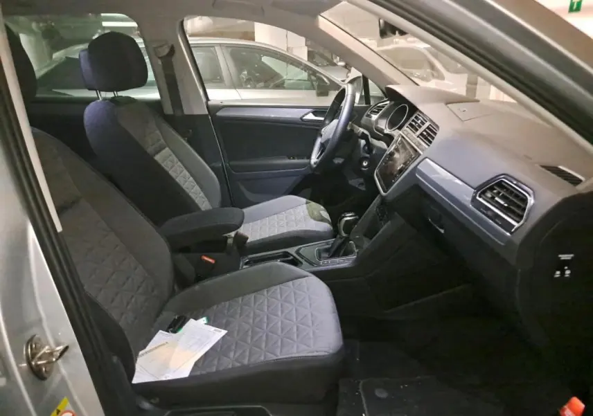 Intérieur avant du Volkswagen Tiguan 2.0 TDI 2022 avec sièges gris et tableau de bord moderne visible côté conducteur.
