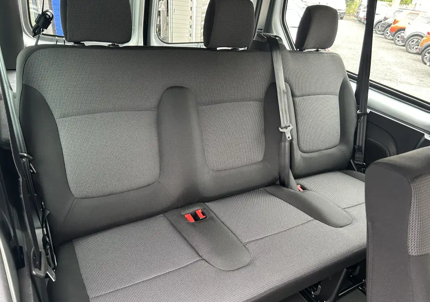 Vue intérieure de la banquette arrière en tissu gris du Renault Trafic Combi L2 Grand Evolution 2025, avec ceinture de sécurité visible.