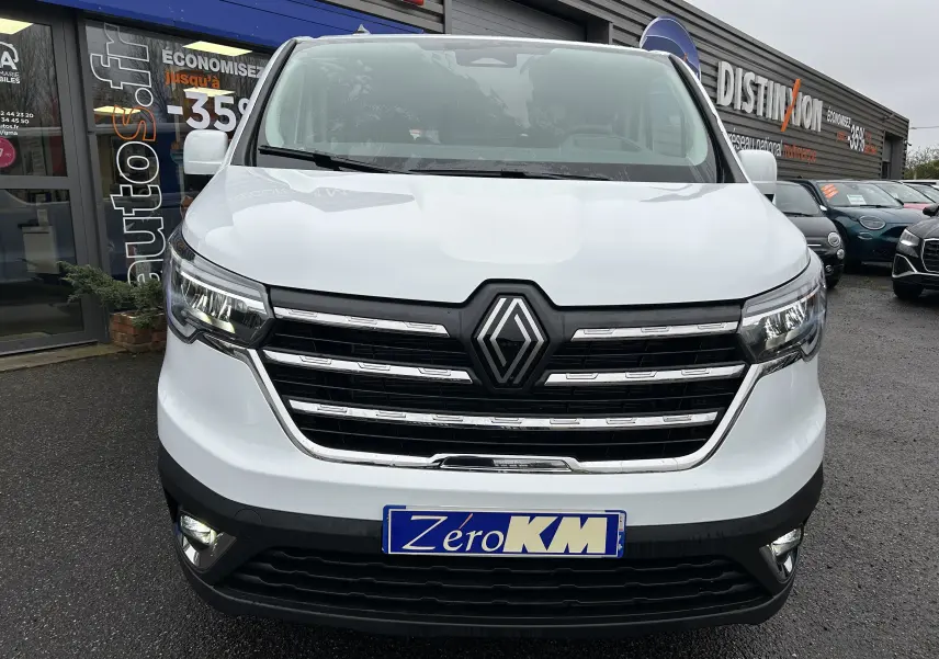 Vue avant du Renault Trafic Combi blanc glacier, mettant en valeur la calandre noire avec logo central et les phares LED.
