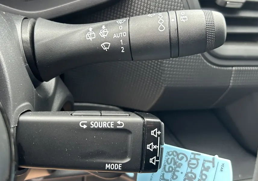 Gros plan sur les commandes au volant du Renault Trafic Combi 2025, avec levier noir et marquages blancs.