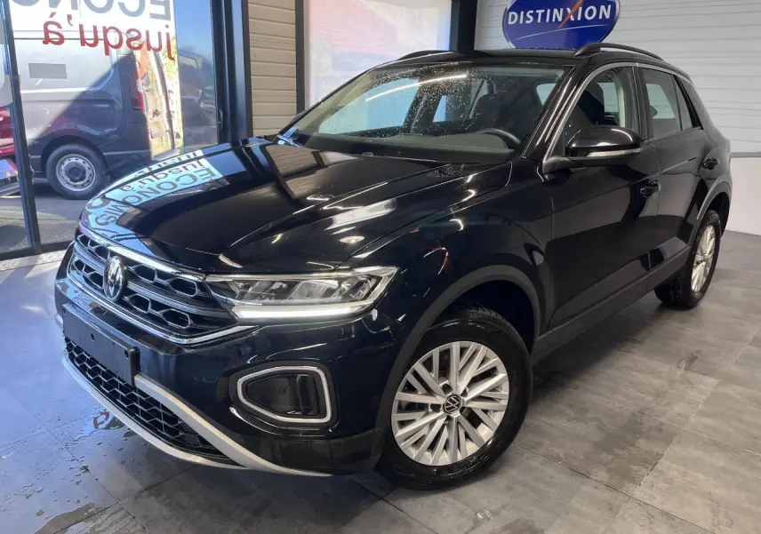 Volkswagen T-Roc Deep Black Pearlescent vue 3/4 avant droit en showroom avec jantes alliage et calandre chromée.