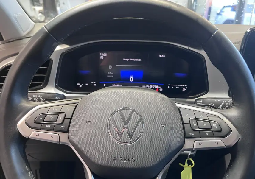 Vue rapprochée du volant en cuir noir multifonction du Volkswagen T-Roc 2025 avec tableau de bord digital allumé.