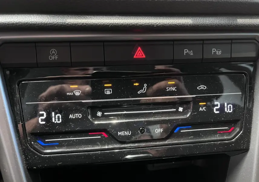 Gros plan sur la commande de climatisation automatique bi-zone du Volkswagen T-Roc Deep Black Pearlescent, affichant 21°C.