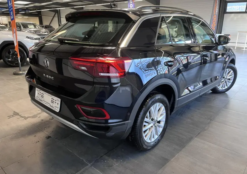Vue 3/4 arrière droit du Volkswagen T-Roc Deep Black Pearlescent avec jantes alliage et feux LED rouges.