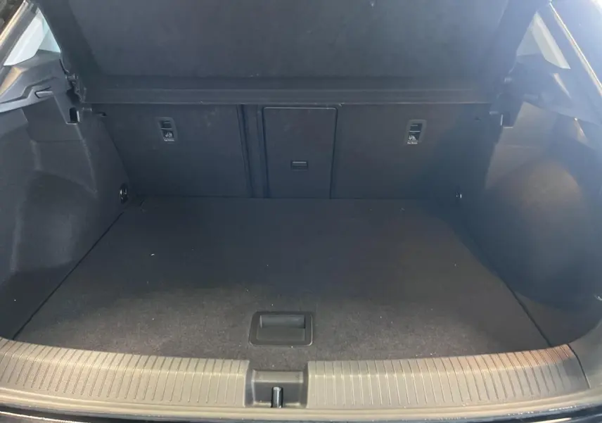 Coffre ouvert vu de face, intérieur spacieux et noir du Volkswagen T-Roc Deep Black Pearlescent 2025.