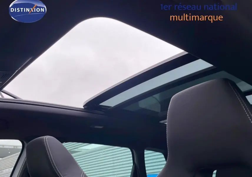 Vue intérieure du toit ouvrant panoramique et sièges avant en tissu noir du Skoda Karoq gris argent 2025 Sportline.