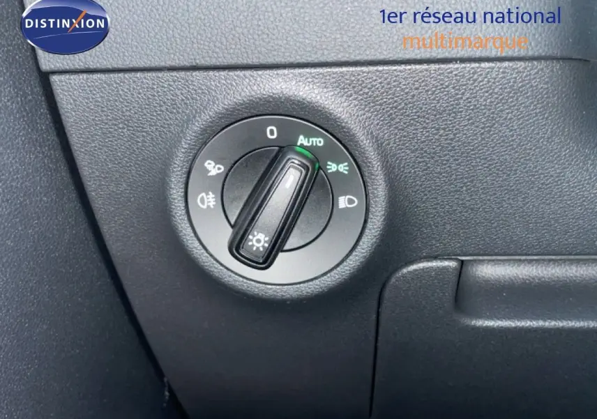 Gros plan sur le bouton de commande des phares du Skoda Karoq gris argent 2025, intérieur noir.