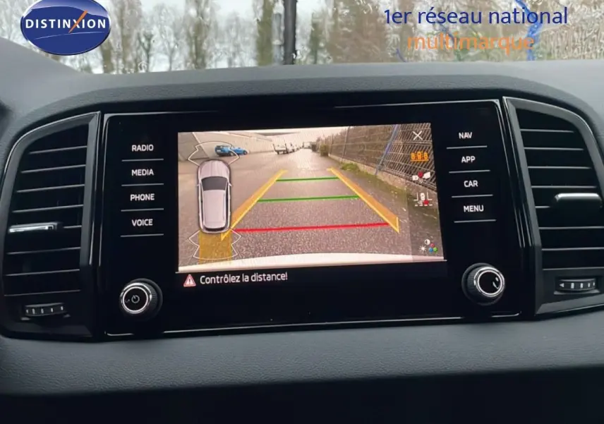 Écran central du Skoda Karoq 2025 montrant la caméra de recul avec lignes de guidage colorées.