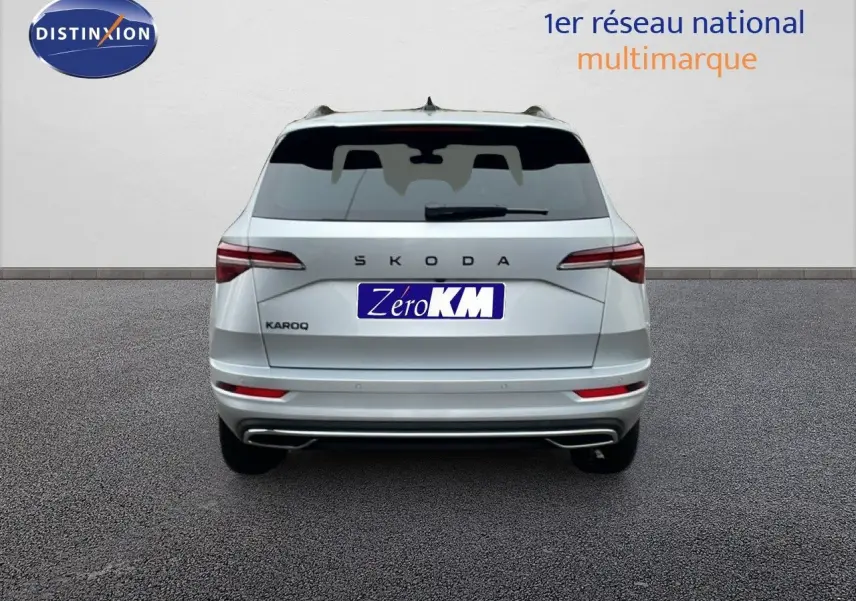 Vue arrière d'un Skoda Karoq gris argent métallisé 2025 avec logo SKODA et feux arrière allongés.