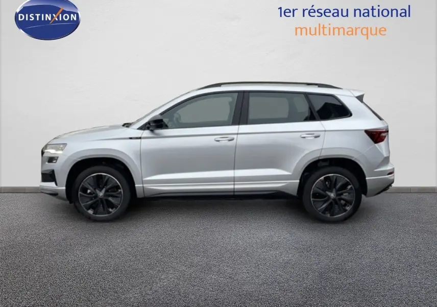 Vue de profil côté gauche d'un Skoda Karoq gris argent métallisé avec jantes noires et toit ouvrant.