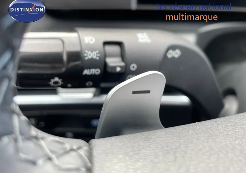Détail du levier de changement de vitesse au volant dans l'habitacle du Hyundai Tucson 2026 blanc Atlas.