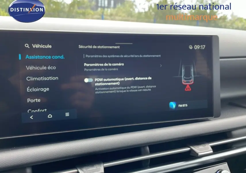Vue rapprochée de l'écran tactile intérieur du Hyundai Tucson blanc Atlas montrant les paramètres d'assistance à la conduite.