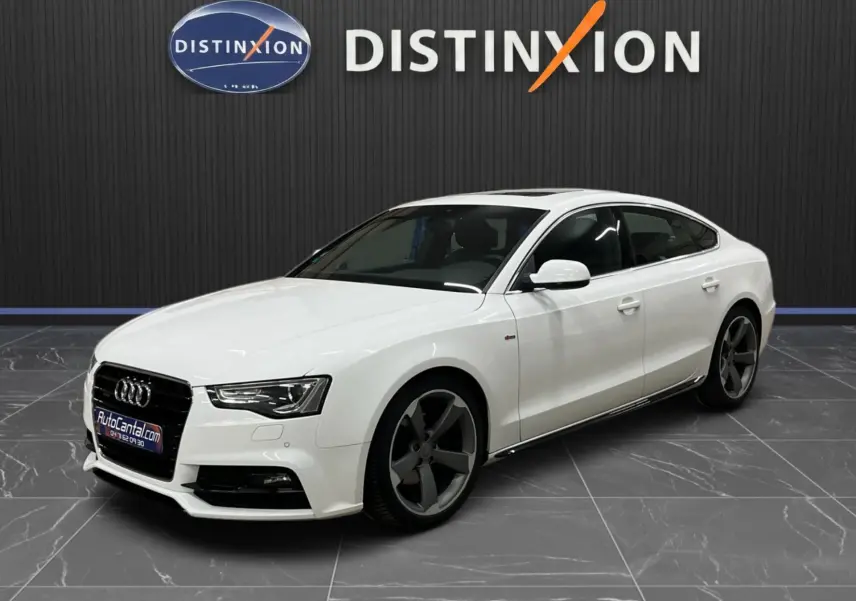 Audi A5 Sportback blanc vue 3/4 avant droit, avec jantes 5 branches foncées et calandre noire distinctive.