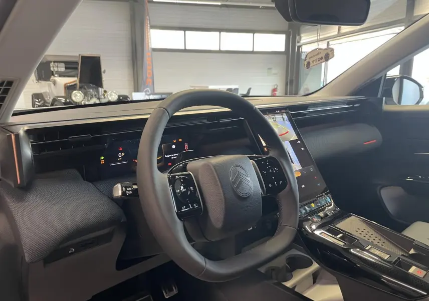 Intérieur du Citroën C5 Aircross 2026 vu côté conducteur, volant noir et écran tactile vertical central.
