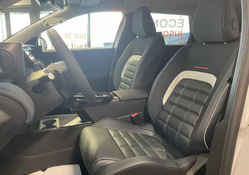 Vue intérieure côté conducteur du Citroën C5 Aircross 2026, sièges noirs avec inserts gris et rouge, volant multifonctions.