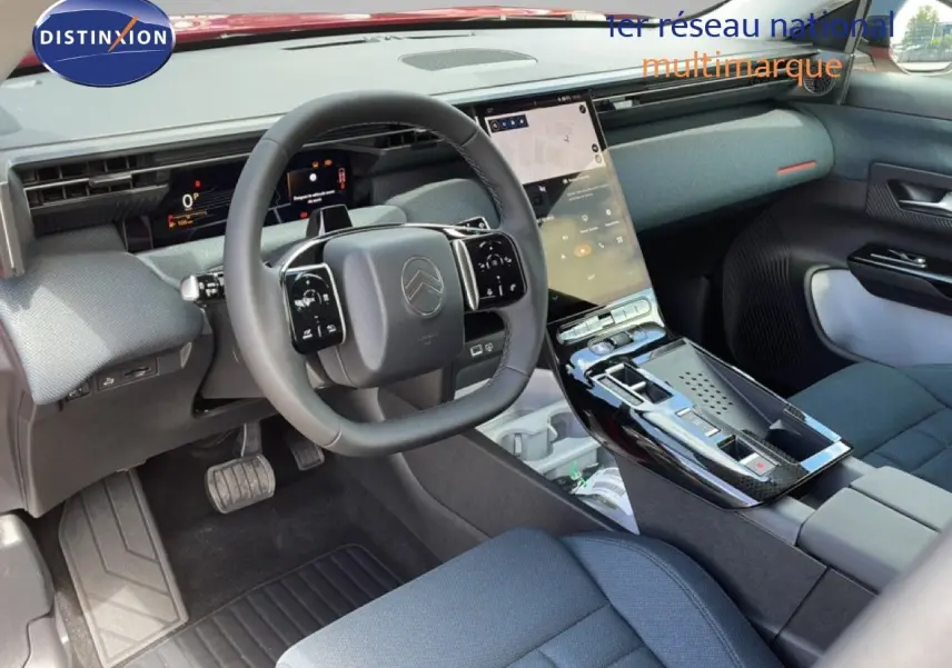Vue intérieure avant du Citroën C5 Aircross Hybrid rouge rubis, mettant en valeur le tableau de bord et la console centrale tactile.