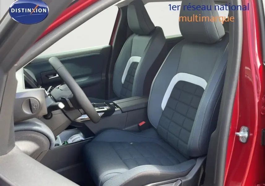 Vue intérieure côté conducteur du Citroën C5 Aircross Hybrid 2026 rouge rubis, sièges tissu noir avec surpiqûres grises.