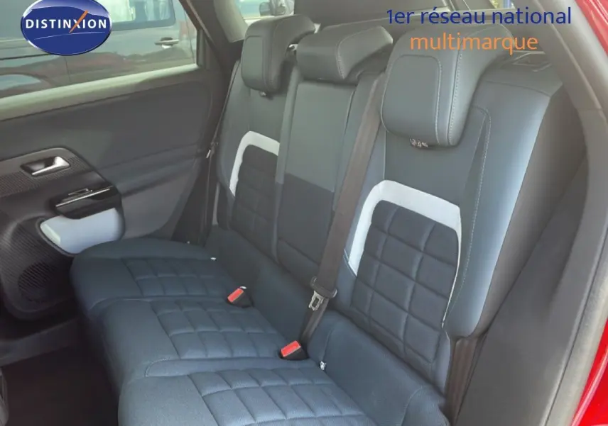 Vue intérieure côté arrière droit du Citroën C5 Aircross rouge rubis, montrant les sièges arrière en tissu noir à motifs carrés.