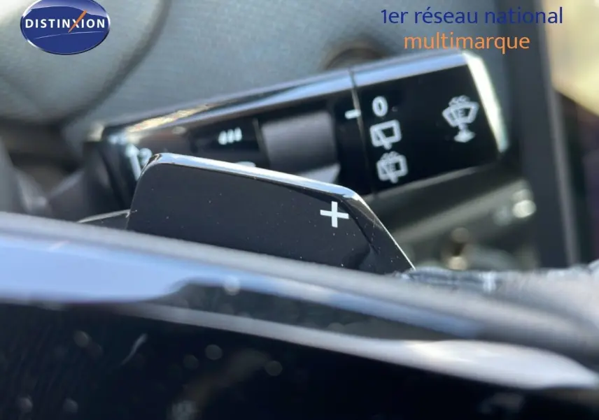 Gros plan sur la palette de changement de vitesse "+" côté droit du volant dans un intérieur de Citroën C5 Aircross rouge rubis.
