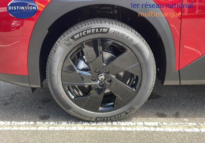 Gros plan sur la roue avant droite noire du Citroën C5 Aircross Hybrid rouge rubis métal, avec jante noire brillante.