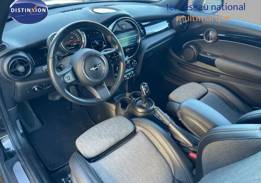 Intérieur avant droit de MINI Cabriolet noir 2023, volant cuir, tableau de bord moderne et sièges tissu gris.