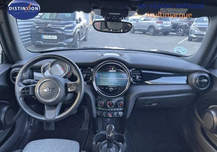 Intérieur de la MINI Cabriolet F57 2023 noir, vue frontale sur le tableau de bord et volant avec écran central rond.