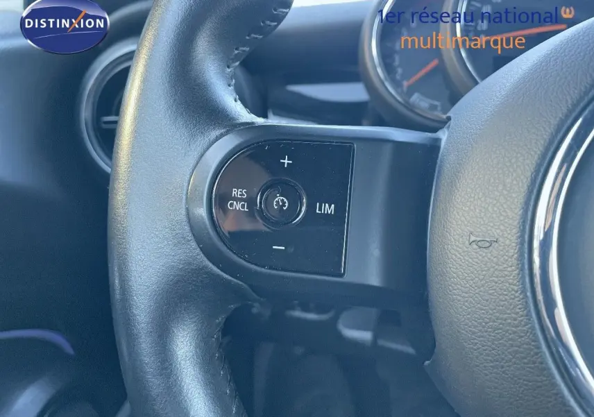 Gros plan sur le volant en cuir noir du MINI Cabriolet F57 2023, mettant en valeur les commandes de régulateur de vitesse.